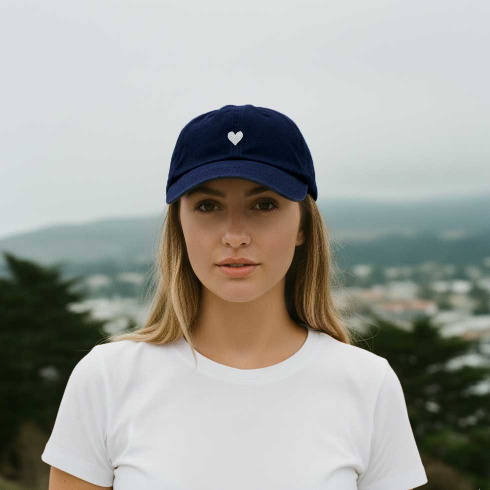 Navy blue cotton baseball cap with a white heart emblem embroidered by Atticus Poetry 