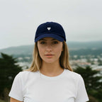 Navy blue cotton baseball cap with a white heart emblem embroidered by Atticus Poetry 